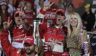 Kevin Harvick celebrates in victory lane with his wife Delana, right, after winning the NASCAR Sprint Cup series Coca-Cola 600 auto race at Charlotte Motor Speedway in Concord, N.C., Sunday, May 26, 2013. (AP Photo/Nell Redmond)