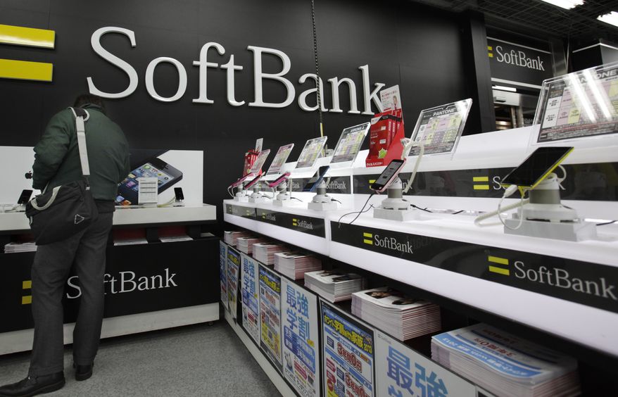 **FILE** A man looks at an iPad mini at an electronics store in Tokyo on Jan. 31, 2013. Japanese phone company Softbank, owned by billionaire Masayoshi Son said its net profit more than doubled in the October-December quarter from a year earlier, helped by strong sales of Apple's iPhone and iPads. (Associated Press)