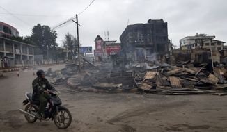A man rides a motorcycle near a burned building that housed an orphanage for Muslim children in Lashio, northern Shan State, Myanmar, on May 30, 2013. Many Buddhists and Muslims stayed locked inside their homes and shops were shuttered after two days of violence in Lashio town, near the border with China, the latest region to fall prey to the country&#39;s spreading sectarian violence. (Associated Press)