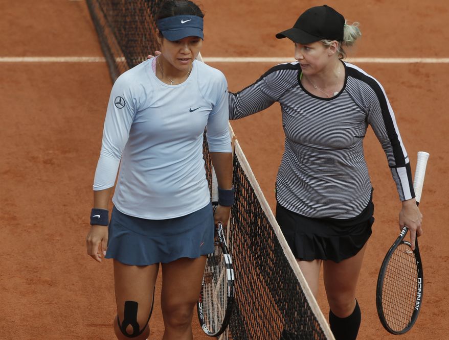 Bethanie Mattek-Sands of the U.S. pats 2011 Roland Garros winner Li Na of China on her shoulder after defeating Li Na in their second round match at the French Open tennis tournament, at Roland Garros stadium in Paris, Thursday, May 30, 2013. Mattek-Sands won in three sets 6-1, 5-7, 6-4. (AP Photo/Michel Spingler)
