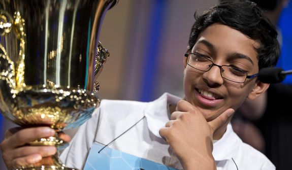 Arvind Mahankali, 13, of Bayside Hills, N.Y., holds the championship trophy after he won the National Spelling Bee by spelling the word &quot;knaidel&quot; correctly on Thursday, May 30, 2013, in Oxon Hill, Md. (AP Photo/Evan Vucci)