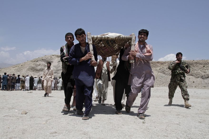 Afghan men carry the bodies of 7 civilians killed, by a roadside bomb in the Alingar district of Laghman province, east of Kabul, Afghanistan, Monday, June 3, 2013. A statement from the provincial government said a group of four women and two children had gone with a male driver into the hills to collect firewood. On their way back, their vehicle hit the mine and all inside were killed. (AP Photo/Rahmat Gul)