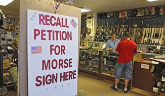 **FILE** A large sign posted at the entrance of Paradise Firearms in Colorado Springs, Colo., invites customers to sign a recall petition against Colorado Democratic State Senate President John Morse on May 24, 2013. In gun-friendly Colorado, gun-rights activists with support of the National Rifle Association are seeking Morse&#39;s ouster for his support of new laws that restrict ammunition magazines and expand background checks to private gun sales. (Associated Press)