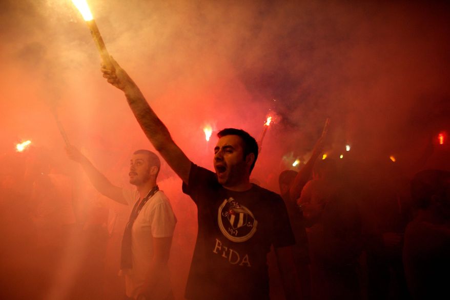 Protesters light flares and shout slogans during a protest at Taksim Square in Istanbul, on Tuesday. Thousands have joined anti-government rallies across since Friday, when police launched a pre-dawn raid against a sit-in protesting plans to uproot trees in the square. Since then, the demonstrations have spiraled into Turkey's biggest anti-government disturbances in years. (Associated Press)