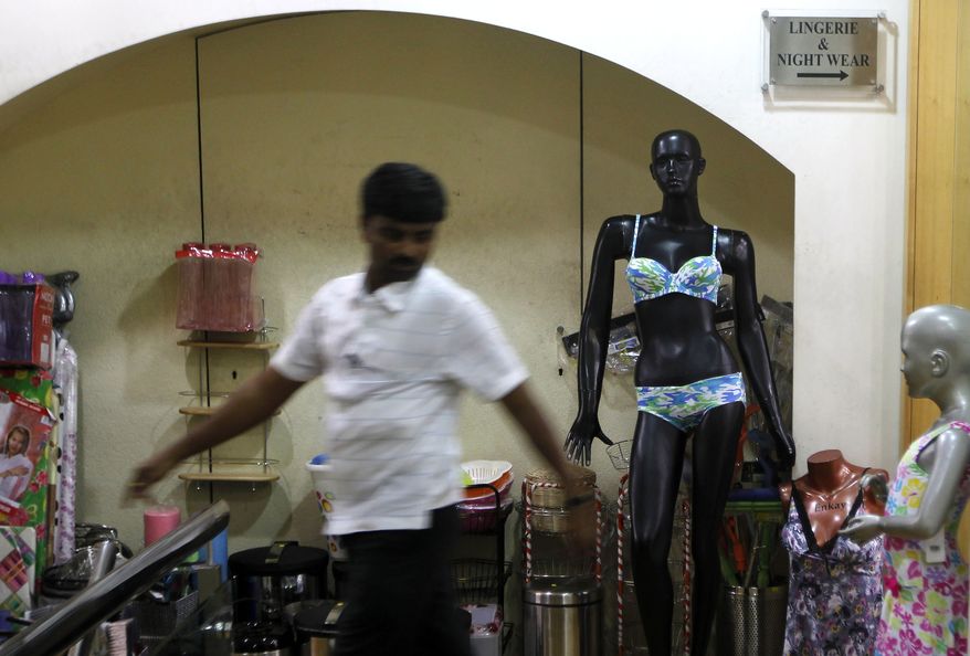 A man walks past a mannequin displaying lingerie at a mall in Mumbai on Friday, May 31, 2013. (AP Photo/Rajanish Kakade)