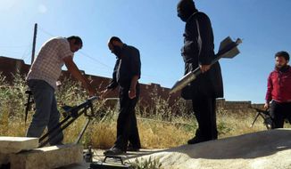 ** FILE ** This citizen journalism image provided by Edlib News Network, ENN, which has been authenticated based on its contents and other AP reporting, shows Syrian rebels preparing to fire locally made rockets, in Idlib province, northern Syria, Tuesday, June 4, 2013. (Associated Press)