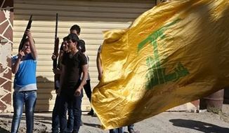 ** FILE ** Hezbollah supporters fire weapons as they celebrate the fall of the Syrian town of Qusair to forces loyal to President Bashar Assad and Hezbollah fighters, in Bazzalieh village, Lebanon, near the Lebanese-Syrian border, on Wednesday, June 5, 2013. (Associated Press)