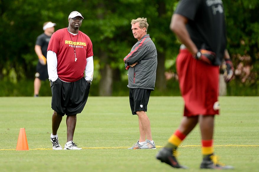 Washington Redskins head coach Mike Shanahan, center, talks with special teams coach Keith Burns, left, during a NFL football organized team activity at Redskins Park, Ashburn, Va., Thursday, June 6, 2013. (Andrew Harnik/The Washington Times)