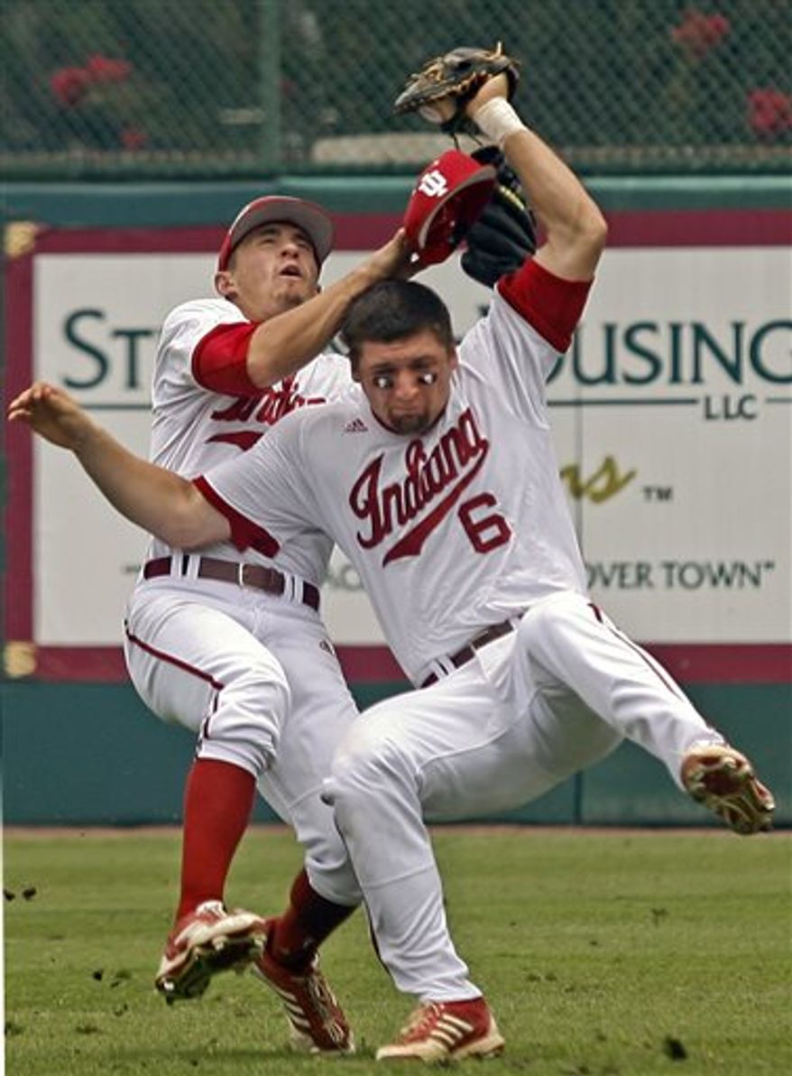 Indiana right fielder Will Nolden, left, and first baseman Sam Travis (6) collide as Travis catches a pop fly hit by Florida State's Jose Brizuela in the first inning of a college baseball tournament super regional game on Sunday, June 9, 2013, in Tallahassee, Fla. (AP Photo/Phil Sears)