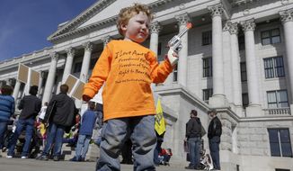 **FILE** Keaton Davidson, 2, holds his toy six-shooter gun during a rally for the 2nd Amendment at the capitol in Salt Lake City on March 2, 2013. (Associated Press)