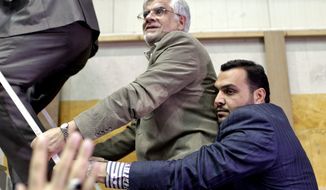 Escorted by his bodyguards, pro-reform Iranian presidential candidate Mohammad Reza Aref (center), a former vice president, arrives at his campaign rally in Tehran on June 10, 2013. The presidential election will be held on June 14. (Associated Press)