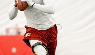 Washington Redskins quarterback Robert Griffin III (10) practices throwing while scrambling at mini camp at Redskins Park, Ashburn, Md., Tuesday, June 11, 2013. (Andrew Harnik/The Washington Times)