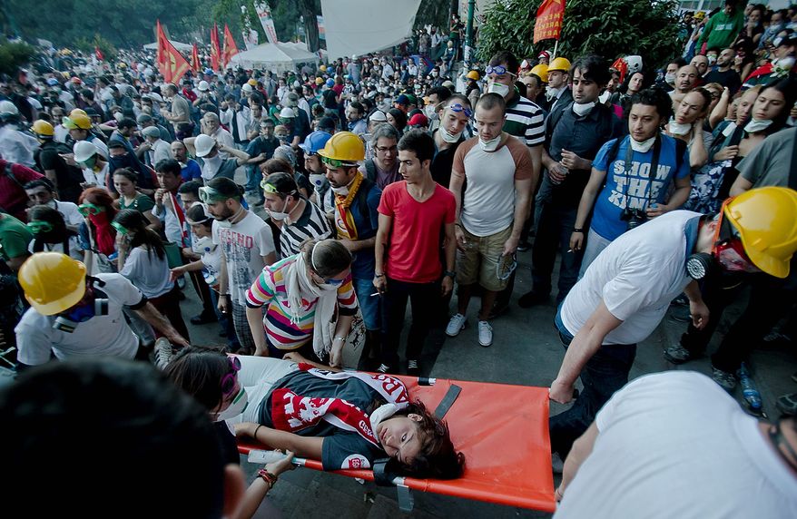 A girl is evacuated on a stretcher after riot police flooded the Gazi Park with tear gas during clashes at Taksim Square in Istanbul on Tuesday, June 11, 2013. Riot police entered the central square after defiant protesters swarmed back in by the thousands. Massive plumes of tear gas billowed upward, and police fired water cannon. (AP Photo/Vadim Ghirda)