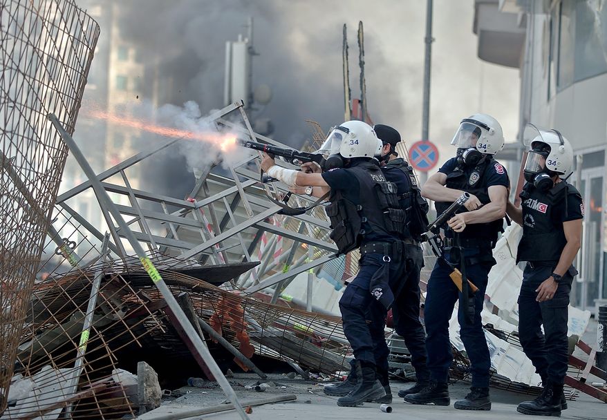 Turkish riot police fire tear gas during clashes in Taksim Square in Istanbul on Tuesday, June 11, 2013. Hundreds of police in riot gear forced through barricades and pushed many of the protesters who had occupied the square for more than a week into a nearby park. (AP Photo/Vadim Ghirda)