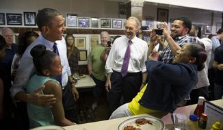 Sean and Natalie Guthrie, of Boston, right, take photos of their 11-year-old daughter Leilani Guthrie posing with President Barack Obama, as he and Massachusetts Democratic Senate candidate, Rep. Ed Markey watch at center during a campaign stop at Charlie&#x27;s Sandwich Shoppe in Boston, Wednesday, June 12, 2013. (AP Photo/Evan Vucci)