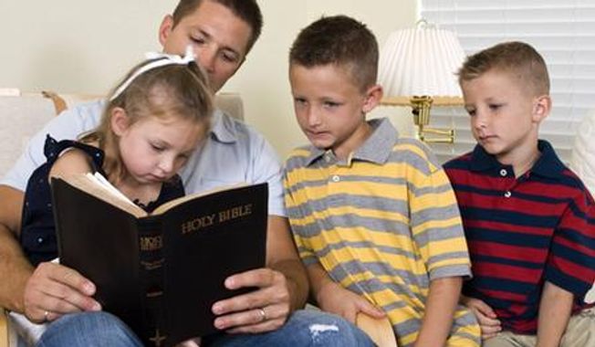 A father reads from the Bible with his children. (Credit: Deseret News)