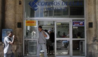 **FILE** A man leaves a postal office in Havana on Nov. 25, 2010. (Associated Press)