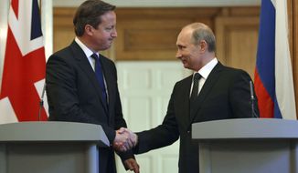British Prime Minister David Cameron, left, shakes hands with Russian President Vladimir Putin during a press conference at 10 Downing Street in London, Sunday, June 16, 2013. Cameron had talks with Russian President Putin on the Syrian crisis amid fears that differences between Moscow and the West are pushing the two sides toward a new Cold War. (AP Photo/Anthony Devlin)

