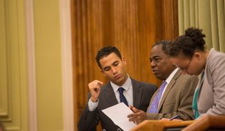 D.C. Council member Vincent B. Orange (center), at-large Democrat, confers with aides before introducing an emergency amendment to bridge the divide between food trucks and bricks-and-mortar restaurants. &quot;This represents a fair compromise. Hopefully we can put this to bed after many years of working on this,&quot; he said. (Andrew S. Geraci, The Washington Times)