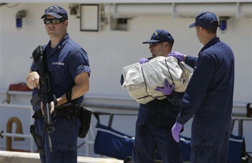 ** FILE ** Coast Guard crew members from the cutter Bernard C. Webber offload bales of cocaine, Friday, April 26, 2013 at the U.S. Coast Guard base in Miami Beach, Fla. The 2,200 pounds of cocaine, worth an estimated $27 million, was seized after stopping a fishing boat in the Western Caribbean Sea. (Associated Press)
