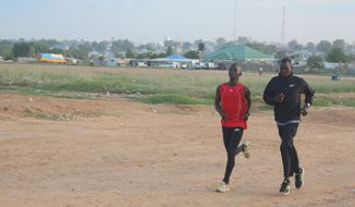 A young athlete joins Guor Mading for a jog in Juba, the capital of South Sudan. (Photograph provided by U.N. High Commissioner for Refugees)