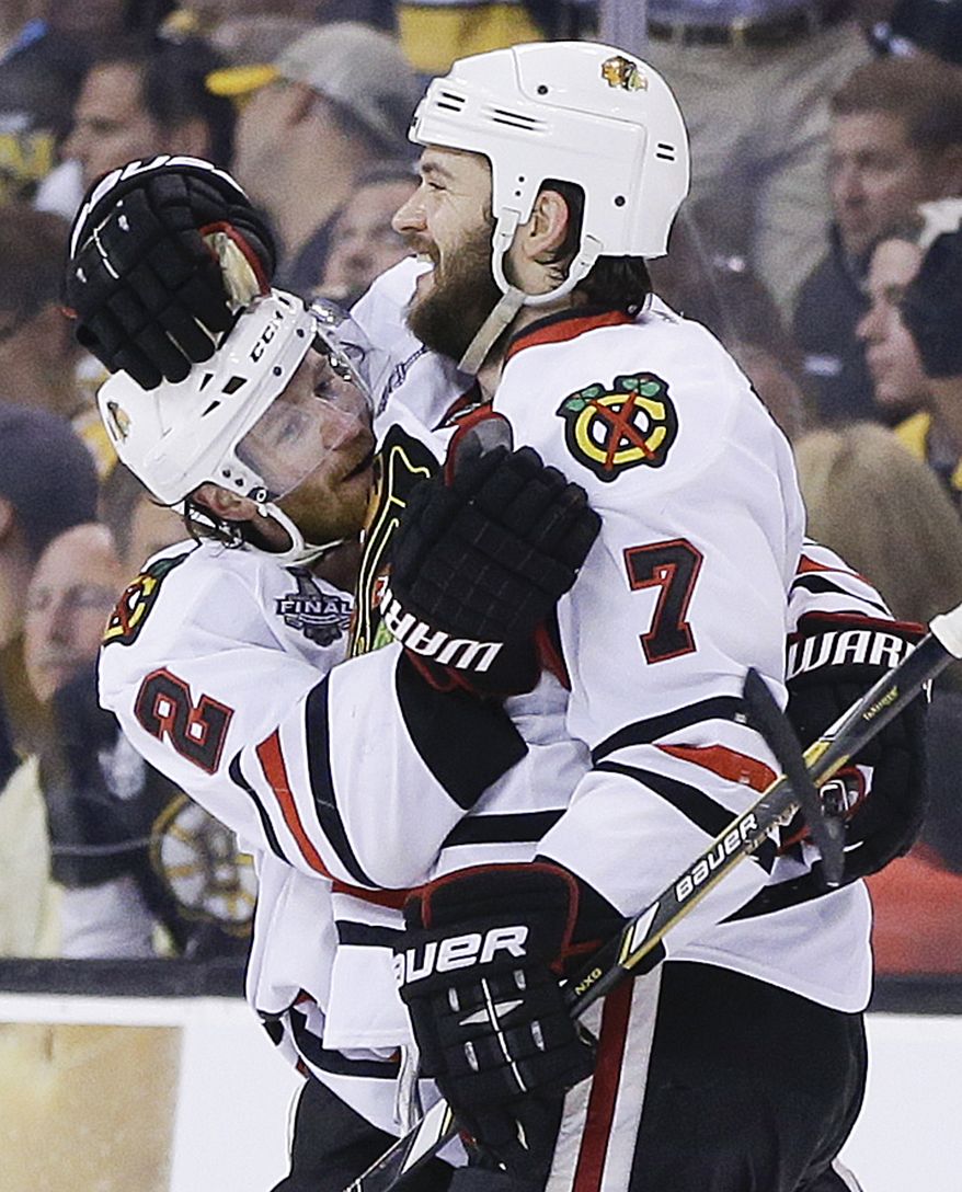 Chicago Blackhawks defenseman Brent Seabrook (7) celebrates his game-winning goal against the Boston Bruins with defenseman Duncan Keith (2) during the first overtime period in Game 4 of the NHL hockey Stanley Cup Finals, Wednesday, June 19, 2013, in Boston. Chicago won 6-5. (AP Photo/Elise Amendola)