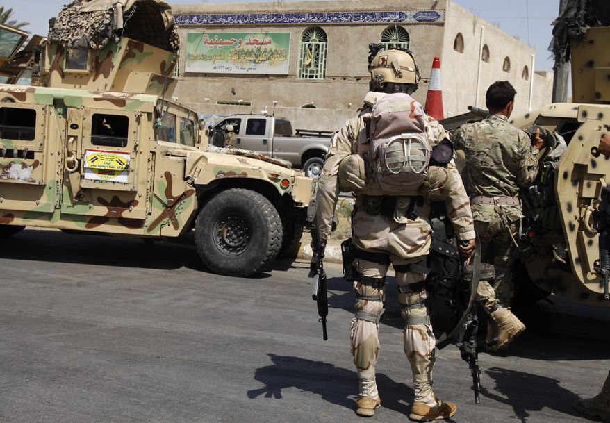 Security forces stand guard at the Habib ibn Mathaher mosque in Baghdad on Tuesday, June 18, 2013, after two suicide bombers blew themselves up at the Shiite mosque, Iraqi officials said. (AP Photo/Karim Kadim)