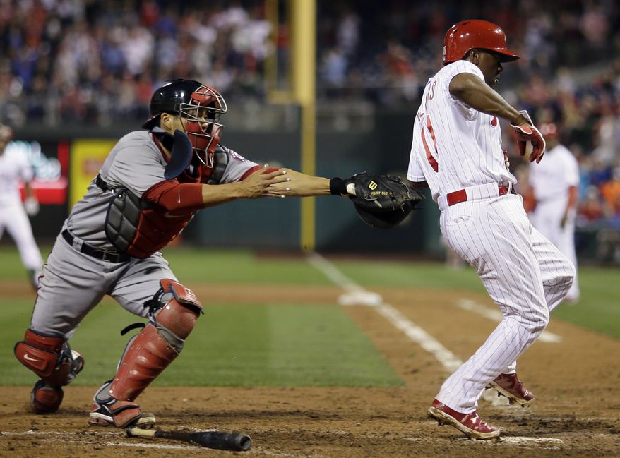 Jimmy Rollins is just out of reach of the tag of Nationals catcher Kurt Suzuki. The Nationals lost to the Phillies on Tuesday night and fell to 34-36 on the season. (Associated press photo)