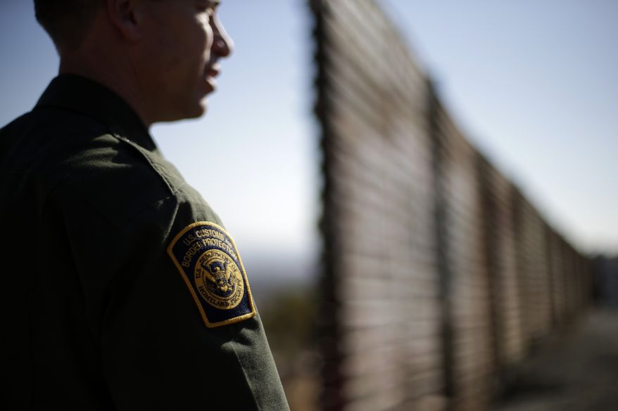 **FILE** U.S. Border Patrol agent Jerry Conlin looks to the north on June 13, 2013, near where the border wall ends as is separates Tijuana, Mexico and San Diego. (Associated Press)