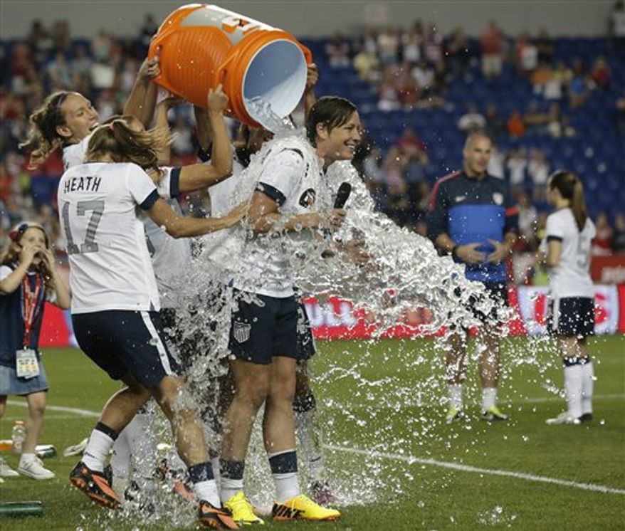 United States' Abby Wambach, right, is showered by teammates after an international friendly soccer match against South Korea at Red Bull Arena, Thursday, June 20, 2013, in Harrison, N.J. The U.S. won 5-0. Wambach is now the greatest goal scorer in international soccer. She scored four goals in the first half to break Mia Hamm's record. (AP Photo/Julio Cortez)