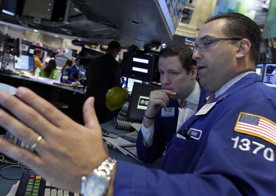 Trading specialists Gregg Maloney (left) and Anthony Matesic confer on the floor of the New York Stock Exchange on Thursday, June 20, 2013, in New York. Financial markets were sliding after the Federal Reserve said it could end its huge bond-buying program by the middle of next year. (AP Photo/Richard Drew)