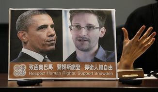 Pro-democractic legislator Claudia Mo Man-ching speaks next to a picture of President Obama and Edward Snowden during a news conference in Hong Kong Friday, June 14, 2013. (Associated Press)