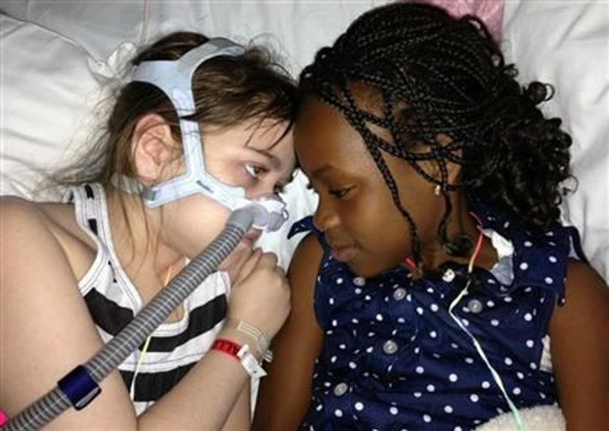 ** FILE ** Sarah Murnaghan, left, lies in her hospital bed next to adopted sister Ella on the 100th day of her stay in Children's Hospital of Philadelphia, May 30, 2013. (AP Photo/Murnaghan Family, File)