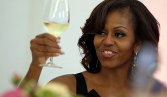 **FILE** First lady Michelle Obama raises her glass for a toast during a dinner at the Charlottenburg palace in Berlin on June 19, 2013. (Associated Press)