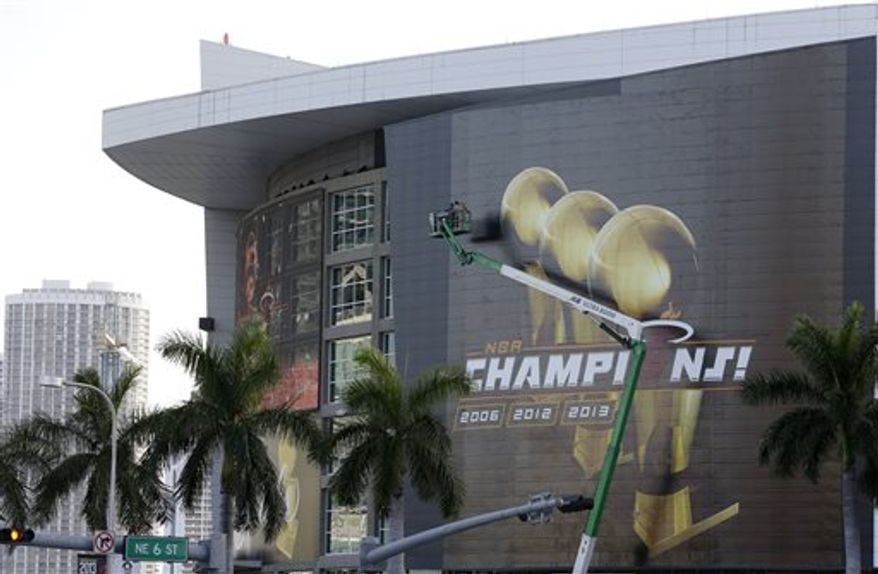 Workers on a boom prepare the outside of the American Airlines Arena before a parade and celebration for the NBA Champion Miami Heat basketball team, Monday, June 24, 2013 in Miami. (AP Photo/Wilfredo Lee)