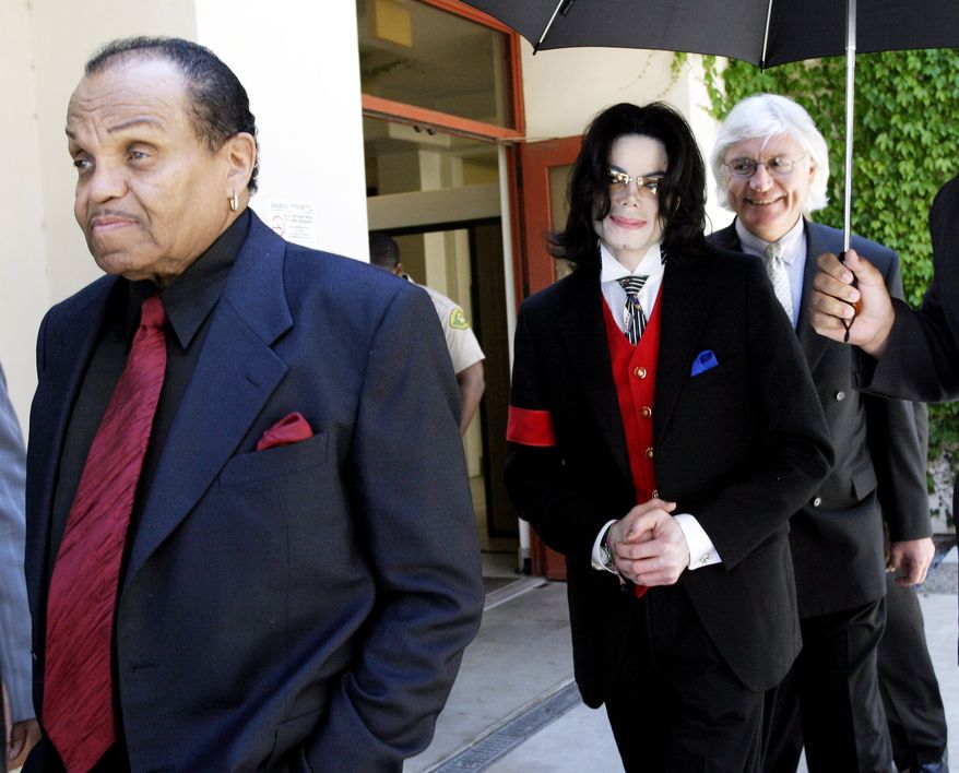 **FILE** Michael Jackson (center), his father Joe Jackson (left) and lawyer Thomas Mesereau leave the Santa Barbara County courthouse on April 29, 2005, in Santa Maria, Calif., as court is adjourned for the day in Michael Jackson's child molestation trial. Superior Court Judge Rodney S. Melville ruled Friday that prosecutors may use as evidence two books seized from the pop star's bedroom in 1993 that feature pictures of nude boys. (Associated Press/WireImage)