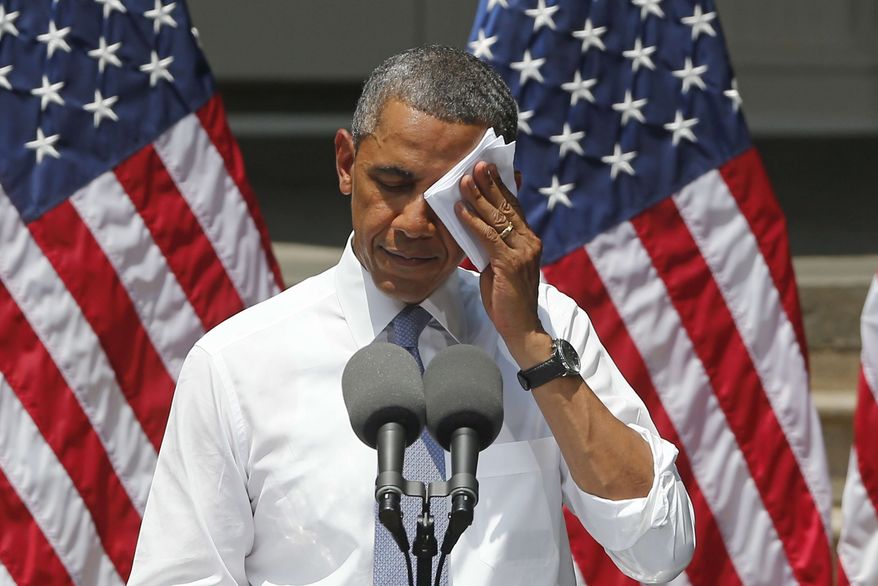 President Obama wipes his face as he speaks about climate change at Georgetown University in Washington on June 25, 2013. (Associated Press) **FILE**