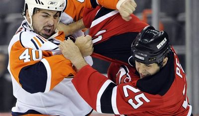 **FILE** New Jersey Devils&#39; Andrew Peters (25) lands a right hand as he fights with New York Islanders&#39; Joel Rechlicz (40) during the first period of a preseason NHL hockey game Tuesday, Sept. 29, 2009, in Newark, N.J. (AP Photo/Bill Kostroun)