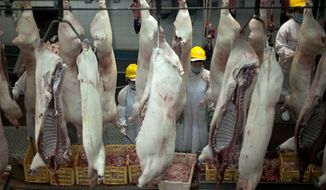 Employees work at a Shuanghui International pork processing plant in Henan province. The sale of Smithfield Foods to China&#39;s Shuanghui International is under scrutiny in Washington because of national security concerns about a Chinese company owning an important U.S. food producer.