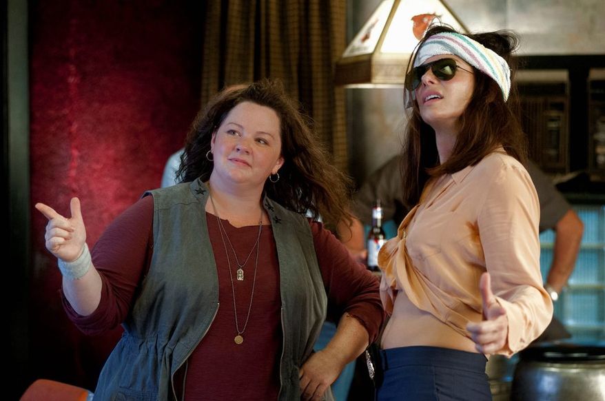 Melissa McCarthy (left) and Sandra Bullock play a mismatched pair of law enforcement officers thrown together on a case in "The Heat." (20th Century Fox via Associated Press)