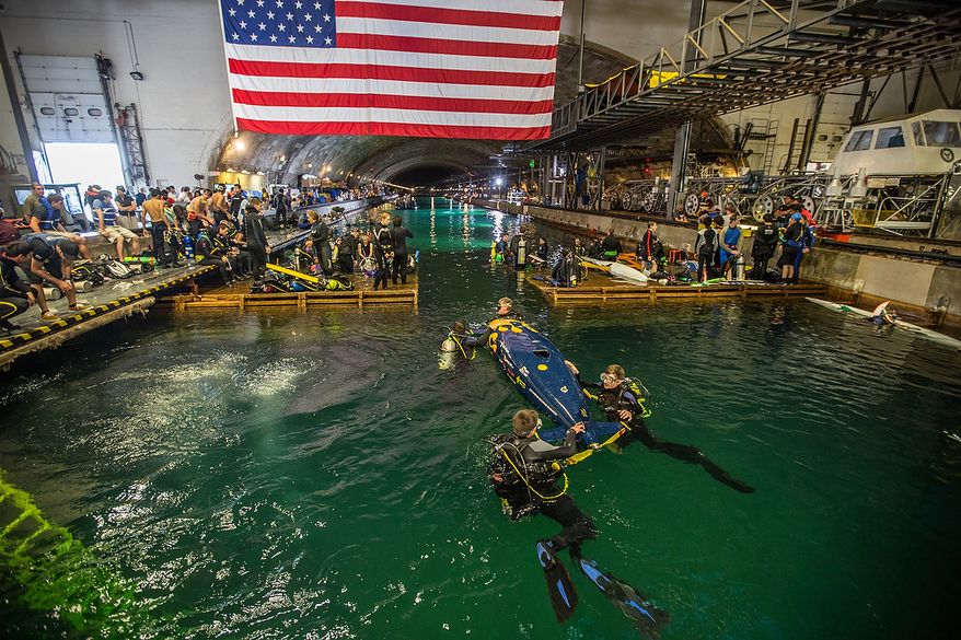 Team members from the "Jesse III", a high-school constructed submarine, swim with their craft to the starting line to compete in the 2013 International Submarine Races at the Naval Warfare Center, Carderock Division, in Bethesda, MD., Thursday, June 27, 2013. (Andrew S Geraci/The Washington Times)