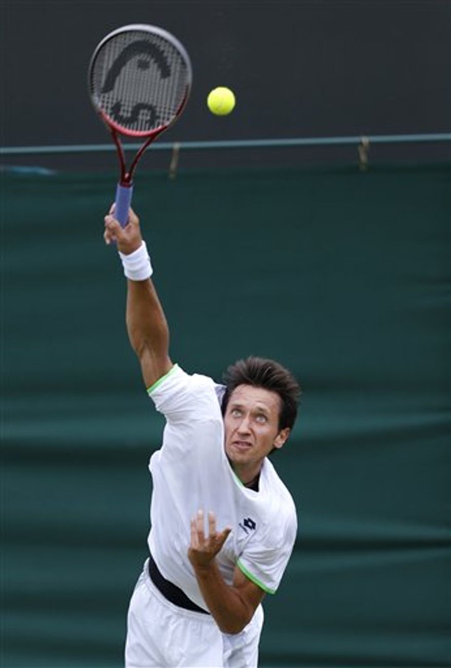 Sergiy Stakhovsky of Ukraine serves to Jurgen Melzer of Austria during their Men&#x27;s second round singles match at the All England Lawn Tennis Championships in Wimbledon, London, Friday, June 28, 2013. (AP Photo/Sang Tan)