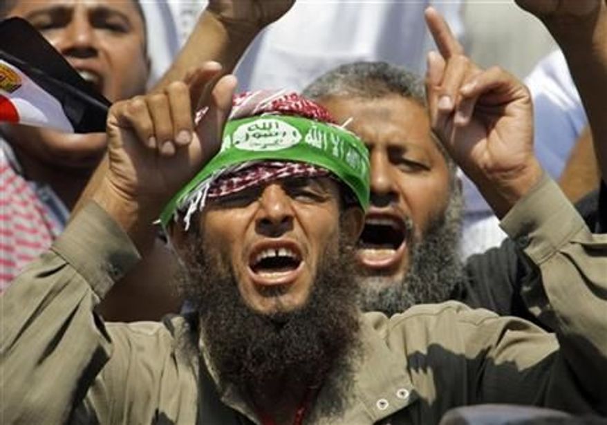 Supporters of Egypt's Islamist President Mohammed Morsi shout anti-opposition slogans at a public square outside the Rabia el-Adawiya Mosque in Cairo, not far from the presidential palace, during a rally in Cairo, Saturday, June 29, 2013. Arabic on the headband reads, "there is no God but Allah and Muhammad is the Messenger of Allah." The demonstrations early Saturday follow days of deadly clashes in a string of cities across the country that left at least seven people dead, including an American, and hundreds injured. (Associated Press)