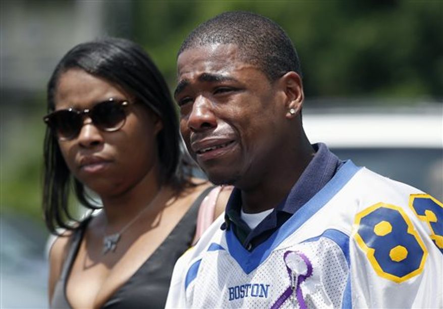 Odin Lloyd's teammate Shaquil Wilkie, right, and an unidentified woman leave Lloyd's funeral service at Church of the Holy Spirit in Boston, Saturday, June 29, 2013. Hundreds of relatives, friends and well-wishers wept together and hugged at the funeral for LLoyd, a semi-pro football player whose killing led to murder and weapons charges against former New England Patriots player Aaron Hernandez. (AP Photo/Michael Dwyer)