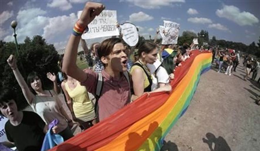 Gay rights activists shout slogans during their authorized rally in St.Petersburg, Russia, Saturday, June 29, 2013. Police detained several gay activists, who were outnumbered by the protesters. Dozens of gay activists had to be protected by police as they gathered for the parade, which proceeded with official approval despite recently passed legislation targeting gays. (AP Photo/Dmitry Lovetsky)