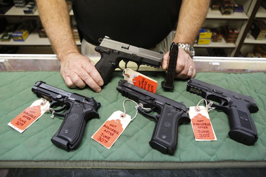 Richard Taylor, manager of the Firing-Line gun store in Aurora, Colo., displays on Thursday, June 27, 2013, some of the pistols that he won't be able to sell after June 30 because their magazines hold more than 15 rounds. (AP Photo/Ed Andrieski)