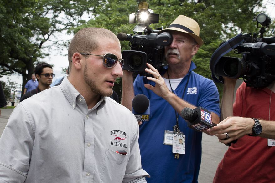 Michael Campbell, 23, the helicopter pilot who made an emergency landing on the Hudson River, leaves the 79th Street Boat Basin on Sunday, June 30, 2013, in New York. The charter chopper was carrying a family of four Swedes on a sightseeing tour of New York City when it lost power shortly after takeoff and made an emergency landing on the river, authorities said. The pilot and occupants were uninjured. (AP Photo/John Minchillo)