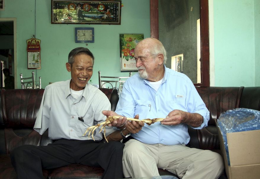Dr. Sam Axelrad (right) hands over arm bones belonging to former North Vietnamese soldier Nguyen Quang Hung at Hung's house in the town of An Khe, Gia Lai province, Vietnam, on July 1, 2013. In October 1966 Axelrad amputated Hung's arm after the soldier was shot in the arm in an ambush by American troops in the coastal province of Binh Dinh in the former South Vietnam. (Associated Press/Thanh Nien Newspaper)
