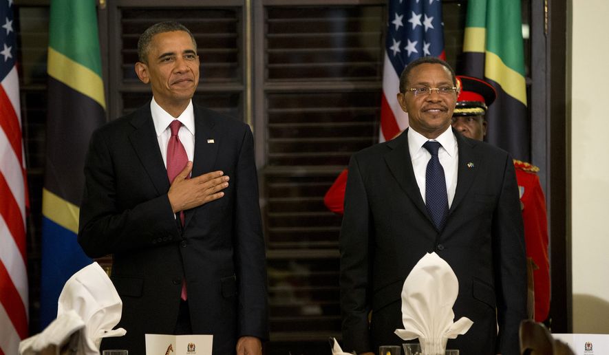 **FILE** President Obama and Tanzanian President Jakaya Kikwete stand for the national anthem during an official dinner at the State House in Dar es Salaam, Tanzania, on Monday, July 1, 2013. Mr. Obama was in Tanzania on the final leg of his three-country tour in Africa. (Associated Press)