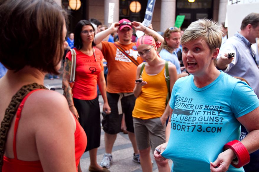 ** FILE ** Anti-abortion activist Pamela Whitehead (right) of Katy, Texas, argues with a pro-choice activist during the first day of hearings on House Bill 2 and Senate Bill 1 at the Texas Capitol in Austin on Tuesday, July 2, 2013. Activists of both sides attended the hearings in order bear testimony about the bills, which are aimed at restricting abortions across the state. (AP Photo/The Daily Texan, Guillermo Hernandez Martinez)